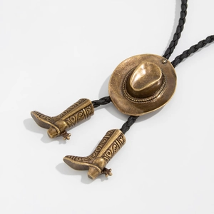 Detalle de corbata bolo vintage en bronce con sombrero de vaquero y colgantes de botas