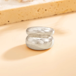 Macro detail van zilveren dubbellaagse metalen ring met ambachtelijke gehamerde textuur
