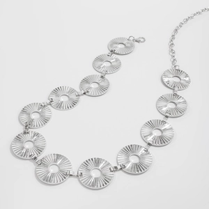 Detail of punk style silver body chain with sunburst textured hollow metal links