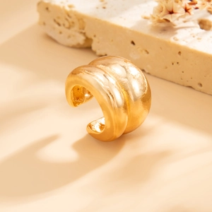 Macro-opname van dikke gouden oorbel met gepolijst metaaloppervlak en maritieme details