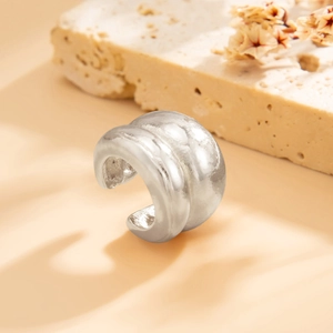 Macro-opname van zilveren earcuff met dubbellaags boogontwerp en unieke textuur