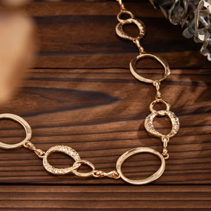 Detail of gold body chain with alternating smooth and hammered metal textured rings
