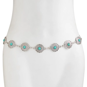 Macro detail of Bohemian sun-carved silver metal rings with turquoise stone inlay on body chain