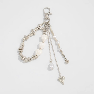 Detailed macro of silver layered keychain with heart beads and faux pearl charms