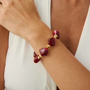 Detail of bohemian choker with irregular dark red resin beads and golden accents