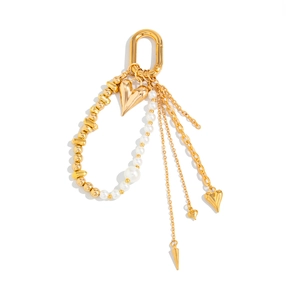 Detailed view of golden heart pendant, white pearls, and tassel chains on a snap hook
