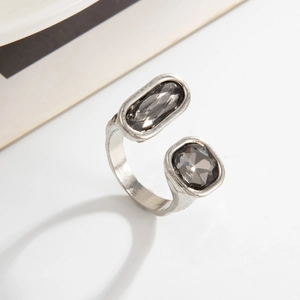 Dettaglio anello aperto argento opaco con pietre preziose grigie su sfondo bianco pulito