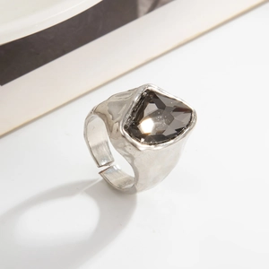 Dettaglio dell'anello con texture lava irregolare, pietra sfaccettata e fascia aperta