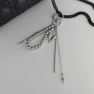 Detail of silver layered multi-pendant accessory with heart, lightning, and CCB bead charms