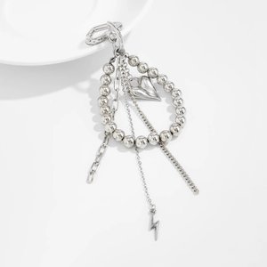 Close-up of silver beaded chain with heart and lightning pendants on a white porcelain dish