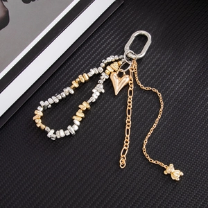 Detailed view of fashion keychain with gold heart charm, bead loop, and bear pendant