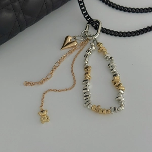 Chic multi-layered accessory with gold heart charm, bear pendant and mixed metal link chains