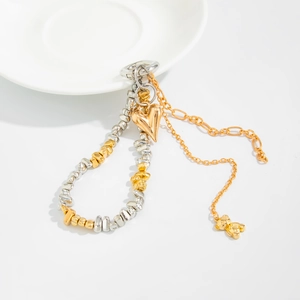 Detail of mixed silver and gold beads with heart and bear charms on a layered chain