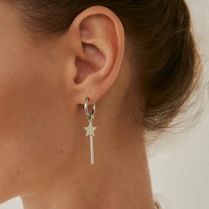 Close-up of stylish silver star drop earring worn by model showing texture and shine