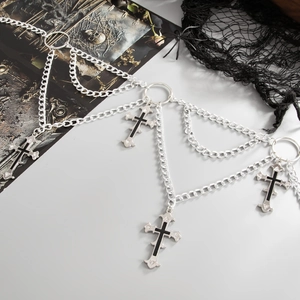 Detail of gothic silver metal body chain featuring cross pendants and layered tassel links