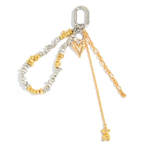 Detail of silver spring hook with golden heart pendant and 3D bear charm on bag chain