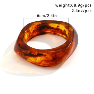 Macro view of amber resin bangle showing detailed measurements and smoky texture