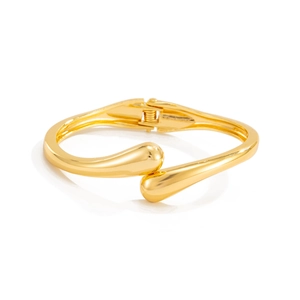 Detailed macro of golden mirror finish bracelet with elegant water drop hinge closure
