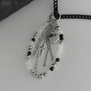 Close-up of a Y2K style silver heart and star charm keychain on a black metal link chain