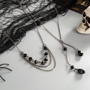 Collier gothique multicouche avec perles noires facettées et détails de pompons noirs