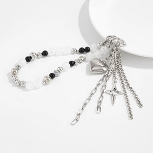 Close-up of heart and star pendants with ice-crack beads on a metallic Y2K pants chain
