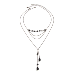 Détail d'un collier gothique noir multicouche avec perles et pendentifs goutte