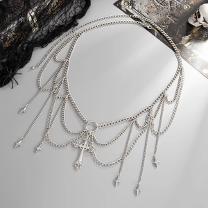 Detailed view of gothic cross pendant and star charms on multilayer silver waist chain