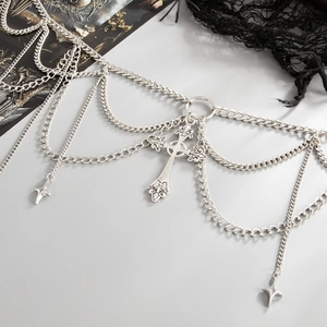 Detail of gothic multi-layer silver body chain featuring cross and star pendants