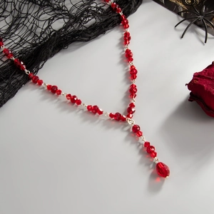 Macro detail of red faceted crystal beads on a Gothic Y-shaped drop fringe necklace