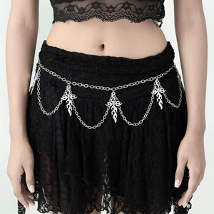 Close-up of gothic silver waist chain with cross and flame charms on black lace skirt