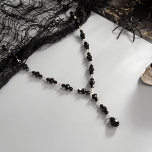 Gothic beaded choker necklace with black crystal drop pendant on themed background