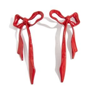 Detail of red bow drop earrings featuring a high-gloss enamel finish and elegant ribbon design