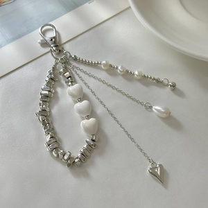 Detail of beaded keychain with ceramic heart, faux pearls and irregular silver beads