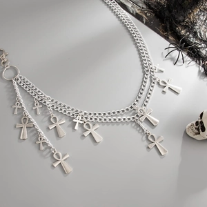 Macro detail of gothic silver layered chains featuring cross and ankh charms with hooks