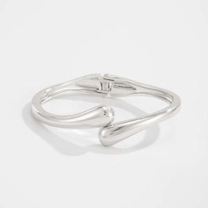 Detail view of silver metal teardrop bangle with spring hinge and polished mirror finish