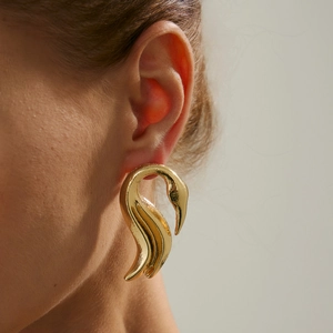 Nahaufnahme eleganter goldener Falt-Ohrstecker mit Hammerschlag-Finish am Model