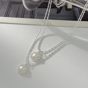 Close-up of double layer silver bead chain with two round white pearl pendants