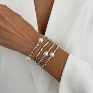 Close-up of four-piece silver beaded bracelet set with baroque pearls and geometric beads