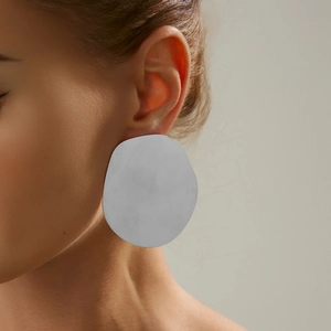 Nahaufnahme von minimalistischen, unregelmäßigen silbernen Ohrringen am Modell