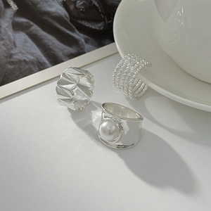 Three-piece silver ring set featuring geometric textures, beaded layers, and pearl detail