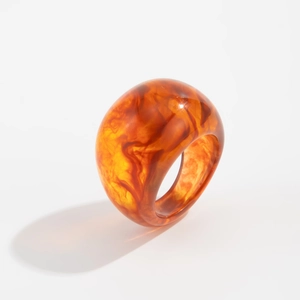 Macro detail of tortoiseshell resin ring with amber marble texture and thick round profile