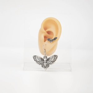 Detail von Gotik-Motte-Totenkopf-Ohrringen und Fledermaus-Ear-Cuff in Antiksilber