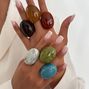 Detail showing oversized resin rings in multiple colors like amber and marble white