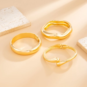 Three-piece gold-plated bracelet set featuring smooth wave and polished geometry designs