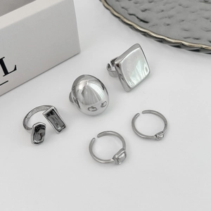 Détail d'un ensemble de bagues en argent avec bande géométrique et cristal gris