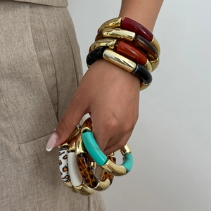 Detalle de pulseras gruesas de resina estilo bambú con detalles dorados y estampado leopardo
