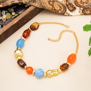 Detail of colorful resin beads and gold irregular metal accents on a bohemian necklace
