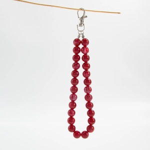 Close-up of red marbled acrylic beaded bag chain with a silver metal lobster clasp