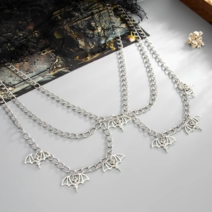 Detail of gothic multi-layer body chain with silver bat pendant and punk style rings