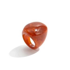 Detailed view of wide amber resin ring with brown marble texture and glossy finish